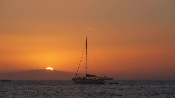 Sunset in Mykonos, Greece and Yachts in the Harbor