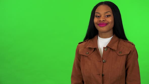 A Young Black Woman Agrees at the Camera with a Smile - Green Screen Studio