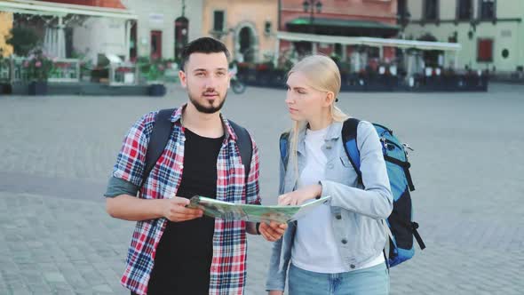 Young Couple of Tourists with Map Looking for New Historical Place in City Center
