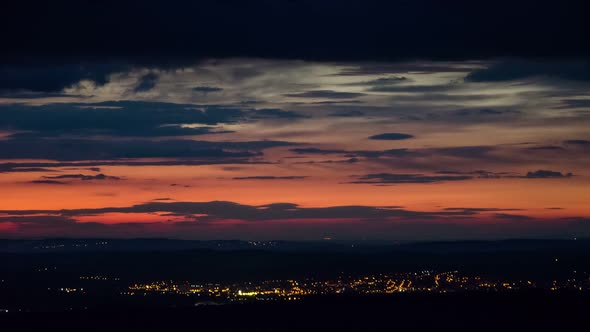 Night Traffic and Clouds Moving over Coloured Sky in Evening in Small City