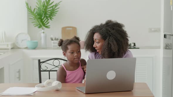 Beautiful Multiethnic Woman in Light Purple Wear Sitting Next to Cute Child They are Communicating