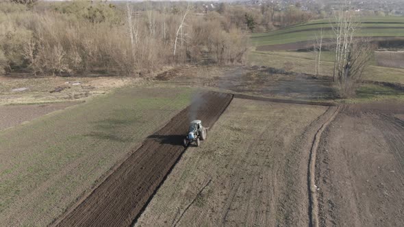 Wide Shot of Tractor Furrowing Soil and Riding To Camera. Agricultural Machinery Working on Fertile