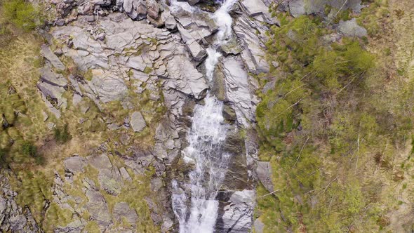 Aerial View of Waterfall Flowing Trough Rocks of Mountain