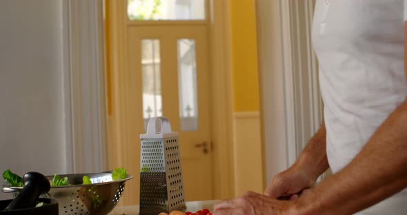 Senior man chopping vegetable in kitchen 