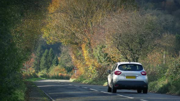 Car Drives In Autumnal Landscape
