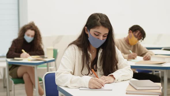 College Students Writing in Classroom