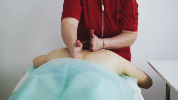 Plump Therapist Does Classical Massage of Patient Sick Back
