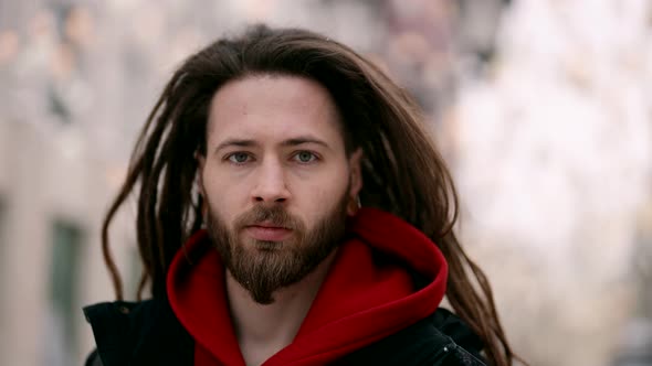 Portrait of Handsome Trendy Man in City Street in Winter Hipster with Dreadlocks and Beard
