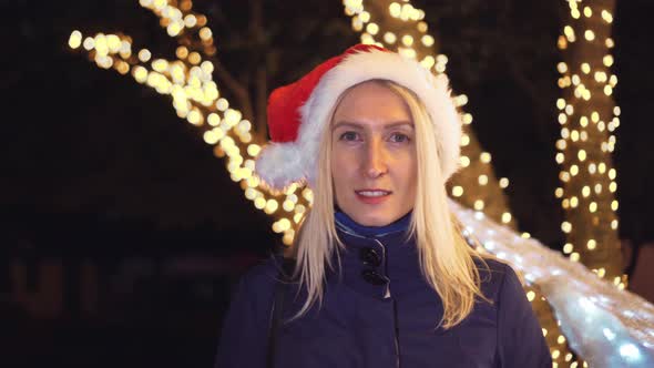 Portrait of a woman smiling at the camera and playing in a Santa hat