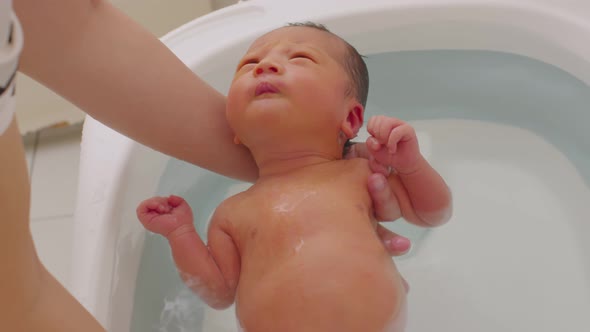 Calm of asian newborn baby bathing in bathtub