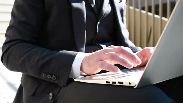 Close up hand businessman tapping keyboard laptop