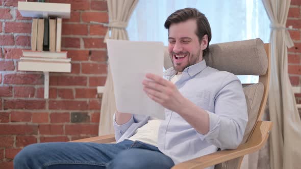 Casual Young Man Celebrating Success on Laptop Sofa