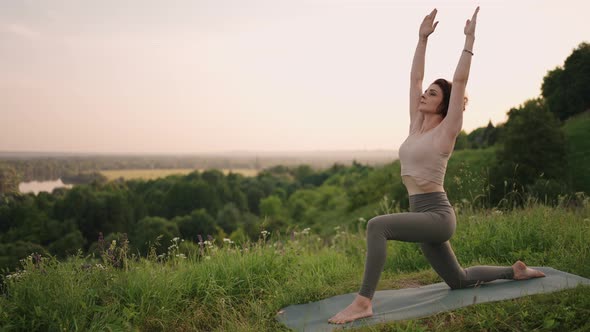 Young Woman Preforms Yoga in Mountains in Morning Light
