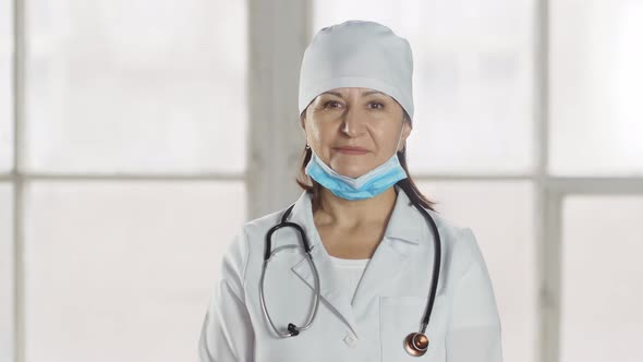 Portrait of a smiling lady doctor taking off mask, looking at camera.professional female doctor wear