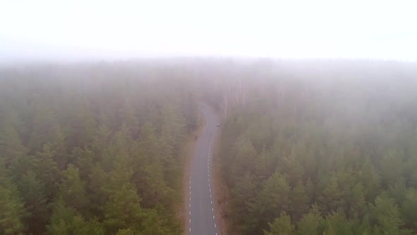 Aerial view of misty road with car parked on roadside in Tahkuna village, Estonia.