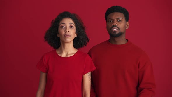 Handsome African couple looking for someone and waving at the camera