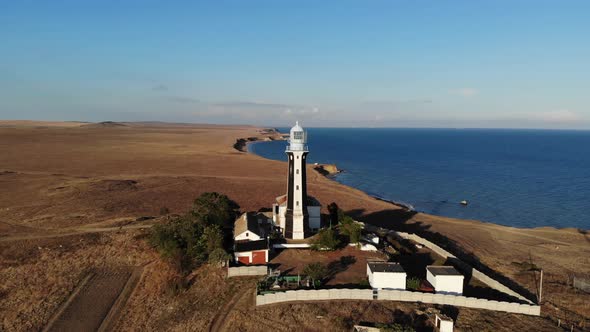 A Typical Striped Lighthouse on the Coast of the Steppe Area in the Evening. Seashore Steep Aerial