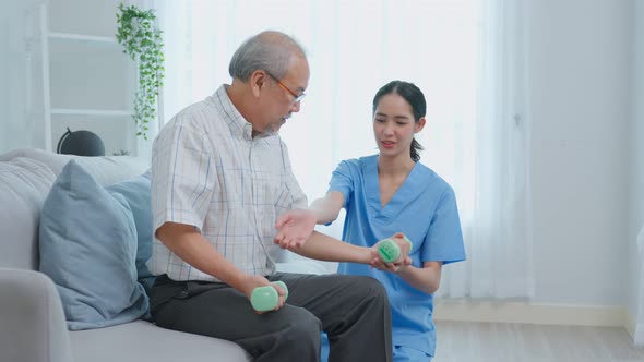 Asian senior older male doing physiotherapist with support from nurse.