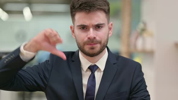 Disappointed Young Businessman Doing Thumbs Down 