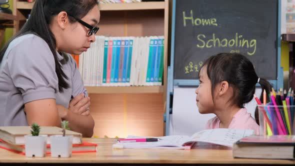 Little girl stops with an angry mother while teaching a lazy schoolgirl at home.