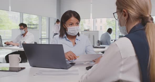 View Over Shoulder of Caucasian Businesswoman Collaborate with African Colleague in Protective Mask