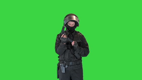 Police Tactical Officer Checking His Hand Gun and Folding Hands on a Green Screen Chroma Key