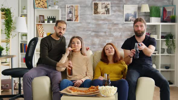 Man Changing Channels on Tv Using Remote Control