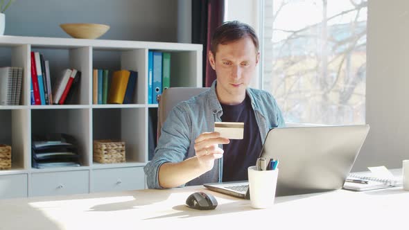 Young male entrepreneur works at home office at the computer.