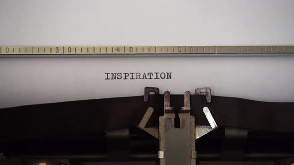 Typing word INSPIRATION on retro typewriter. Close up.