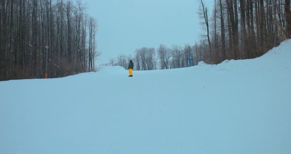 Snowboarder Quickly Moves Out of a Snowy Mountain Snow Flies Into the Camera