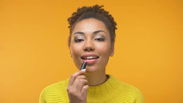 African-American Girl Applying Lipstick and Winking
