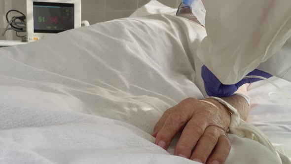 Doctor in Protective Suit Take Care Patient Oxygen Mask. Unrecognizable Person