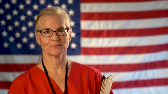 Medium tight portrait of a healthcare nurse with glasses walking toward camera happy with an out of