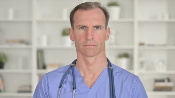 Portrait of Serious Middle Aged Doctor Looking at Camera