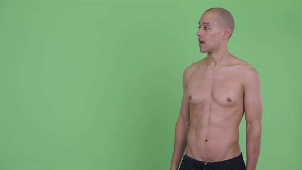 Happy Bald Multi Ethnic Shirtless Man Touching Something and Looking Surprised