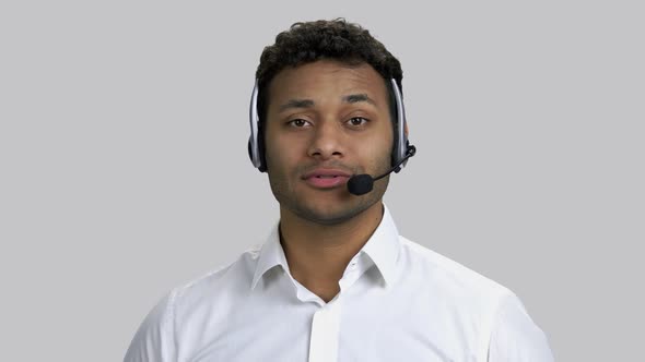 Portrait of Happy Darkskinned Man with Headset Is Talking