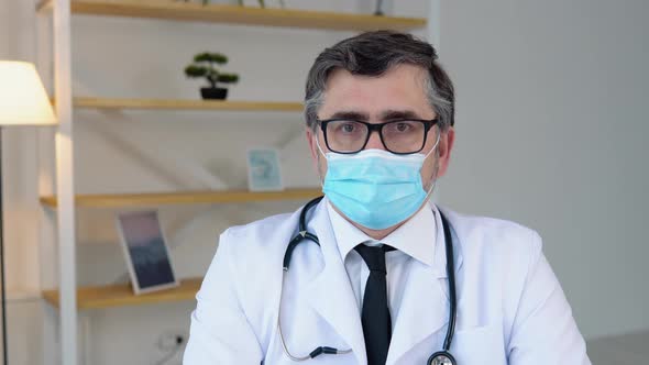 Portrait of a Senior Doctor in White Suit and Protective Mask