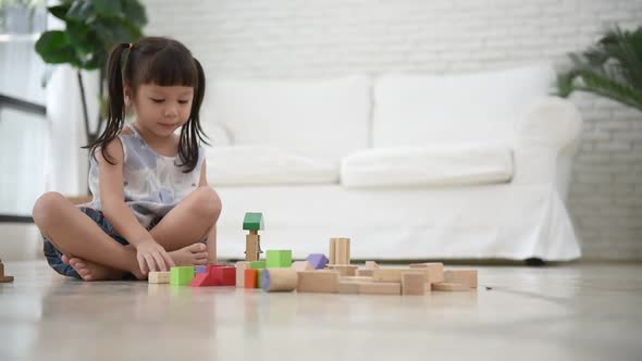 Asian girl playing wood blocks toy