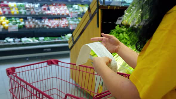 Woman Checks Paper Check After Shopping for Groceries at Mall By Checking Dear Amount Bill in a