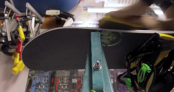 Workshop With Snowboard Repair Tools. Master Is Cleaning The Board. Low Angle