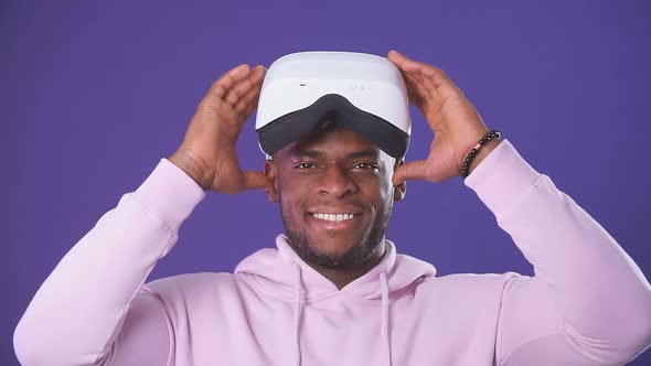 African Handsome Man Wearing a Sports Hoodie Wearing a VR Headset From His Head