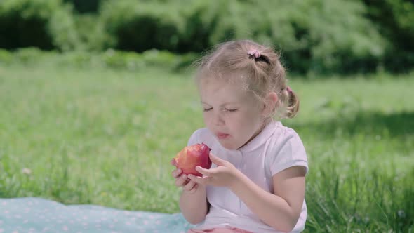 Healthy Nutrition. Child Eating Juicy Apple Outdoors