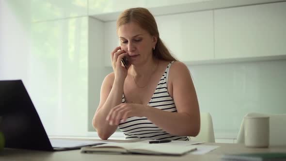 Woman with Phone Works in Front of Computer at Spbd Home