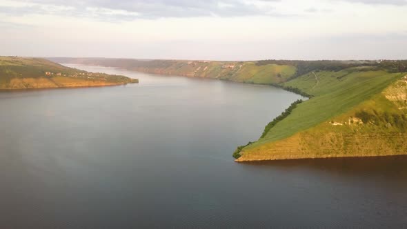 Aerial view of wide Dnister river and distant rocky hills in Bakota area, part of the National park 