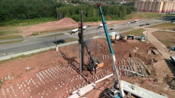 A Large Vertical Piledriving Crane Hammers Reinforced Concrete Piles Into the Ground at a