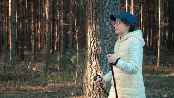 Active Tourist Woman in Cap and Glasses During Nordic Walking