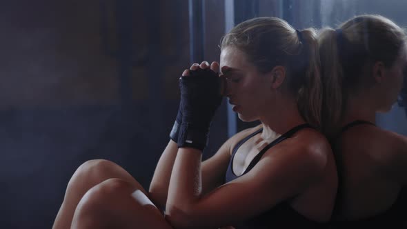 Tired Sweaty Boxer Woman is Sitting Leaned Back on the Mirror in the Boxing Gym After Hard Training