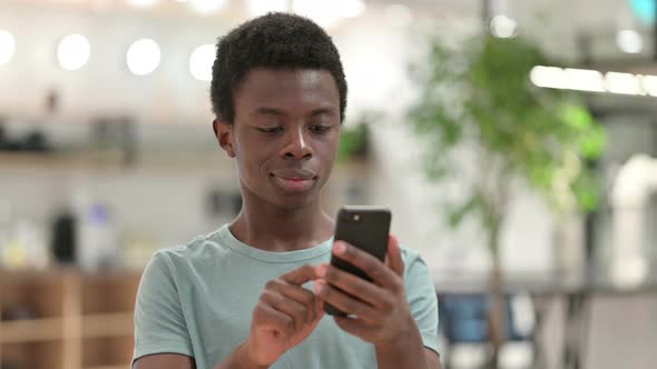 Young African Man Using Smartphone, Text Messaging