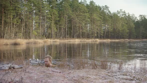 ZOOM IN WS - An ice bather focuses on conscious breathing as he sits in a frozen lake
