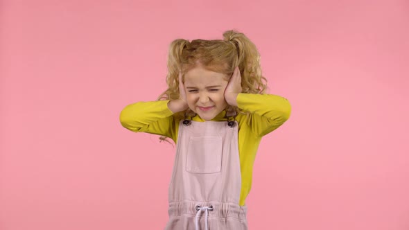 Little Cute Girl Is Covering Her Ears in Studio